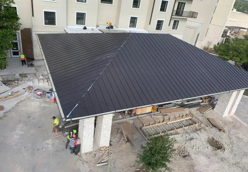 Metal roofing installation team working on a commercial building in San Diego